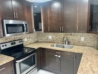 a kitchen with stainless steel appliances granite countertop a sink stove and microwave
