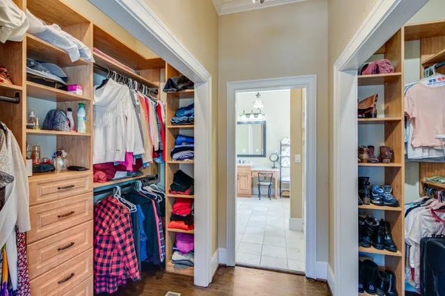 a view of walk in closet with clothes and shoes