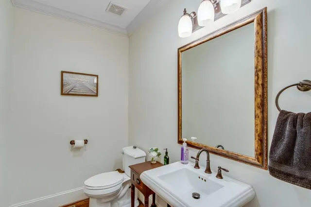 a bathroom with a sink mirror and toilet
