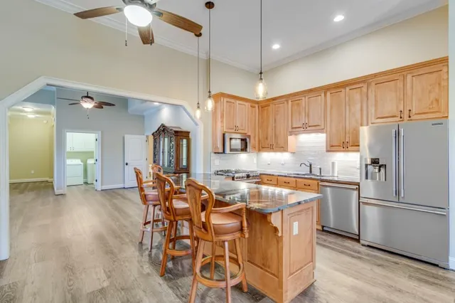 a kitchen with stainless steel appliances granite countertop a refrigerator and a stove top oven