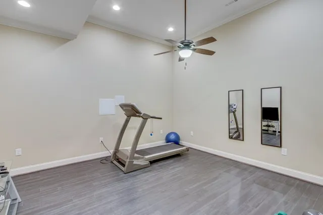 a room with gym equipment and wooden floor