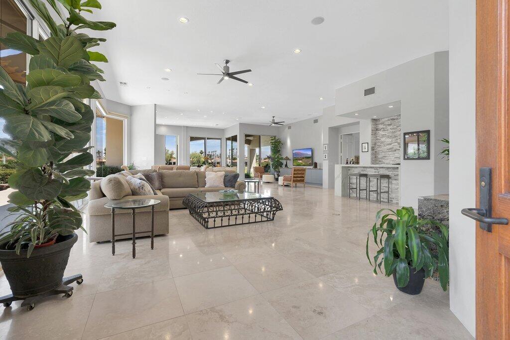 79860 Tangelo La Quinta, CA 92253 - Photo 7 of 45 a living room with furniture a potted plant and a kitchen view