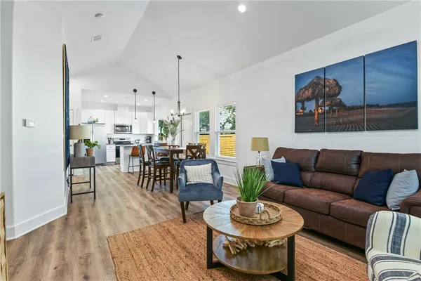 a living room with furniture a dining table and a chandelier