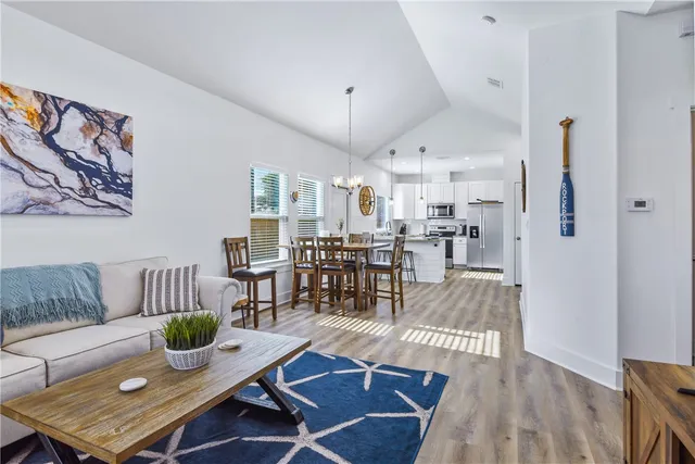 a living room with furniture and a dining table with kitchen view