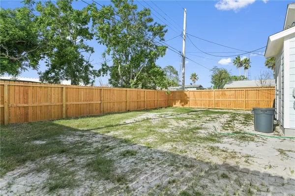 a view of backyard with wooden fence