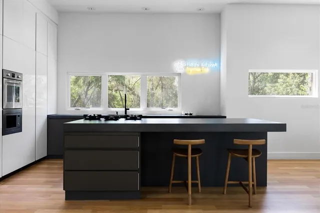 a kitchen with a sink cabinets and wooden floor