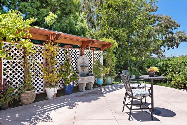 a view of a patio with a table and chairs under an umbrella