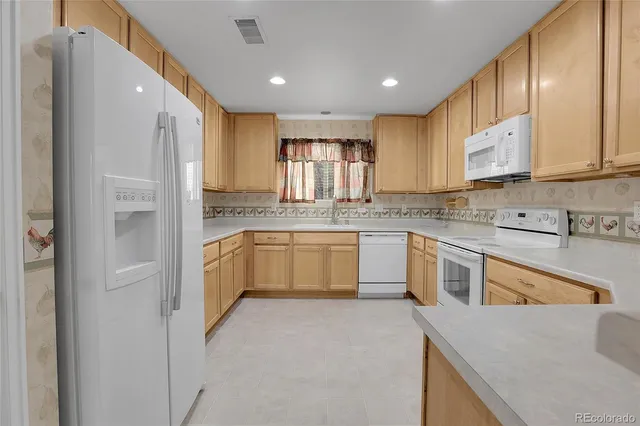 a kitchen with a refrigerator sink and cabinets