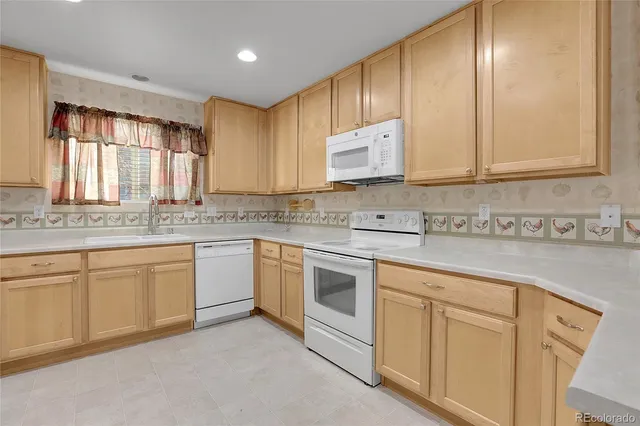 a kitchen with cabinets appliances a sink and a window