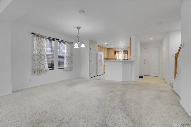 a view of a big room with windows and chandelier