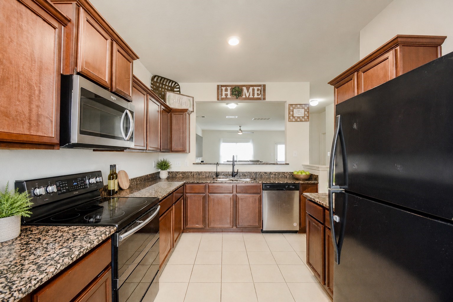 1322 Emerald Stone Drive Rosharon, TX 77583 - Photo 4 of 23 a kitchen with stainless steel appliances granite countertop a stove refrigerator sink and microwave