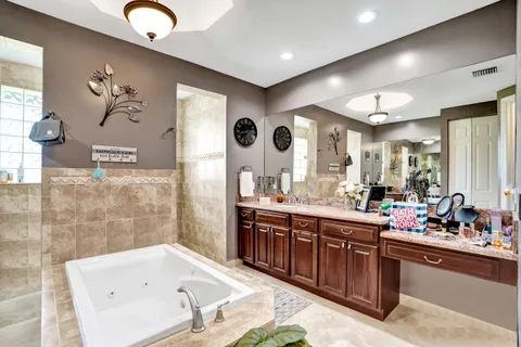 a bathroom with a tub sink and mirror