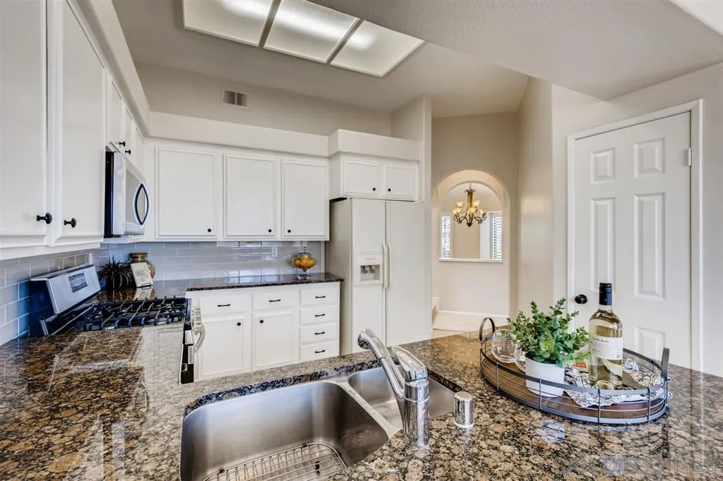 5034 Frazee Road Oceanside, CA 92057 - Photo 11 of 25 a kitchen with stainless steel appliances granite countertop a sink a stove and a refrigerator
