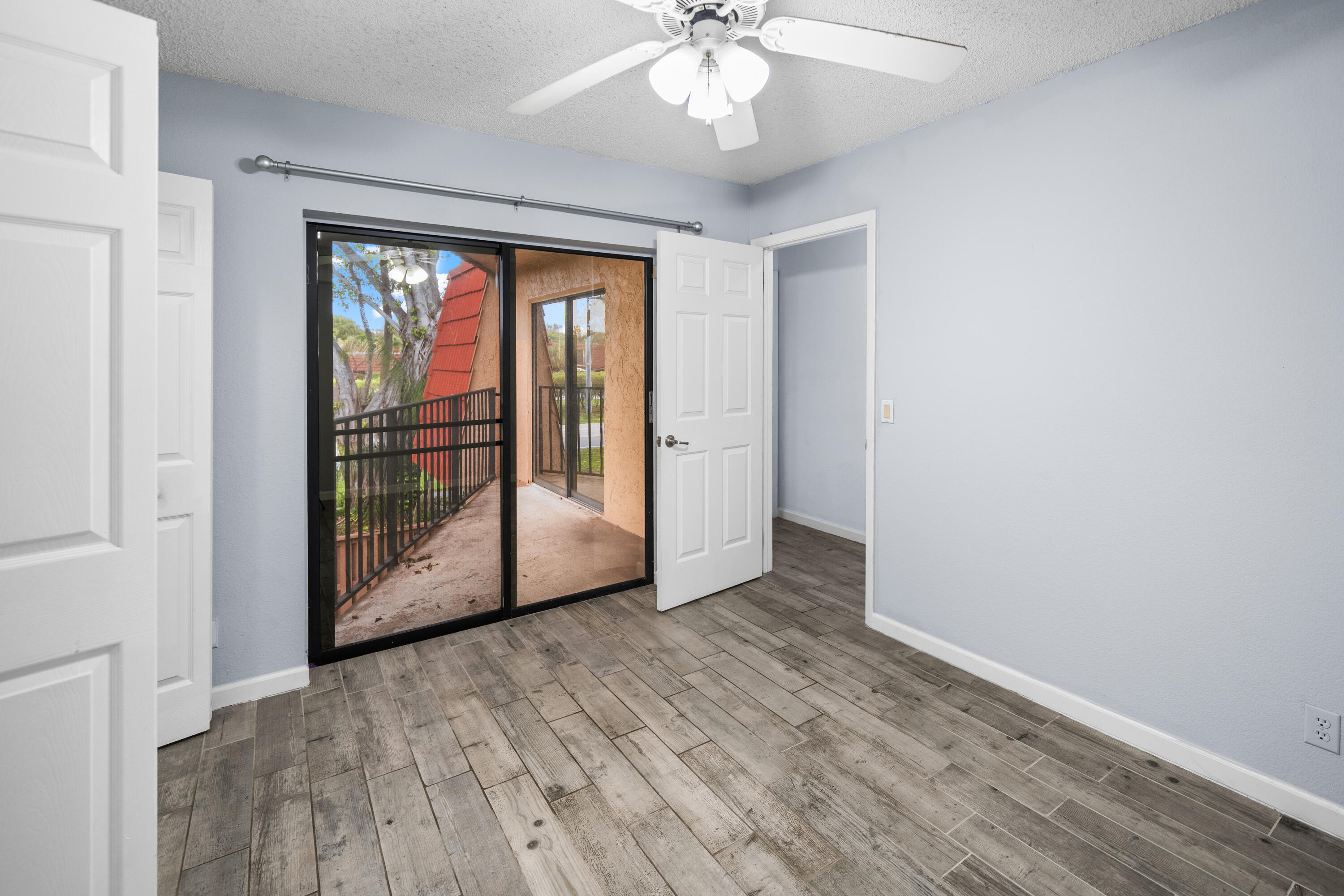 8237 Severn Drive, Unit A Boca Raton, FL 33433 - Photo 13 of 19 an empty room with wooden floor and windows