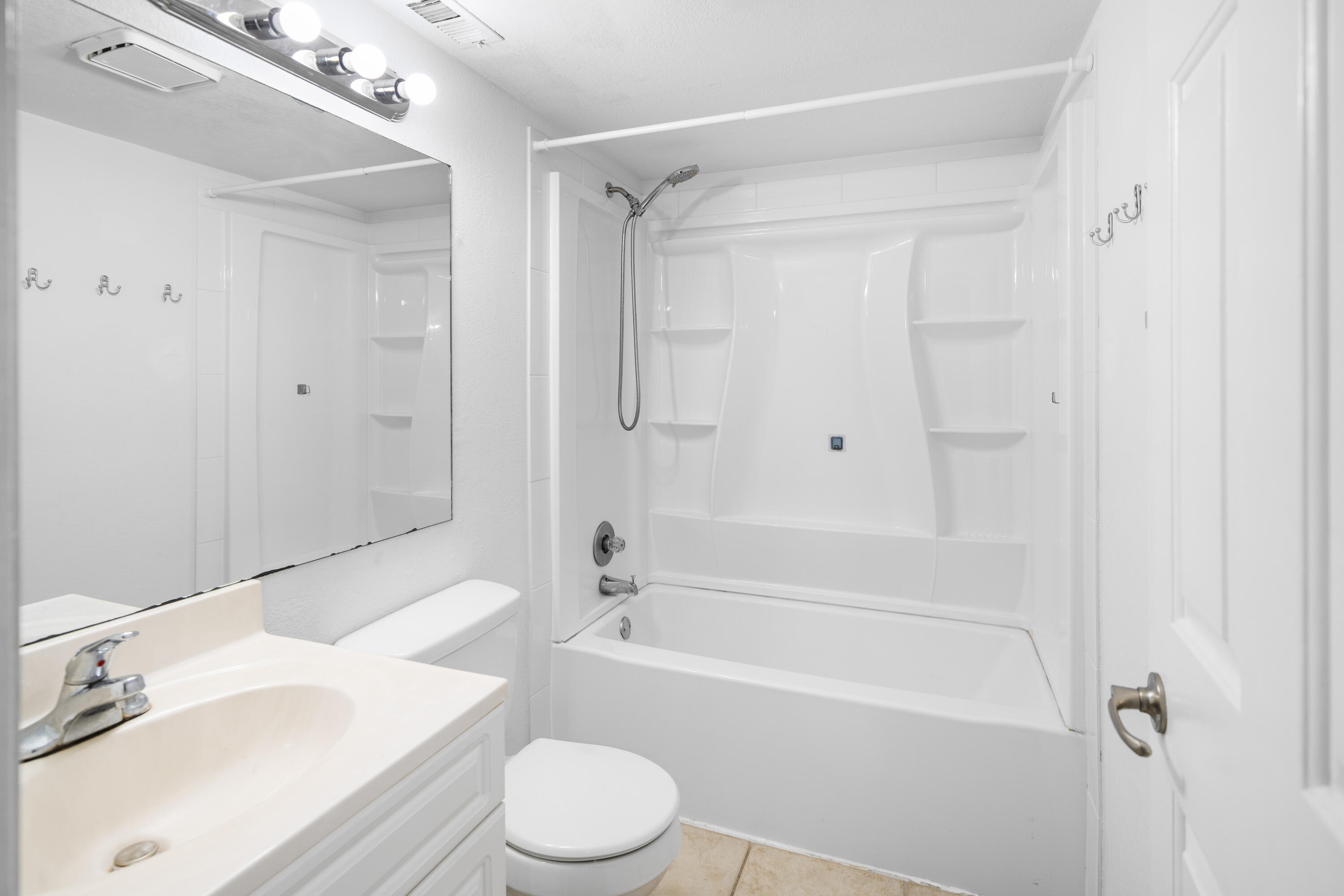 8237 Severn Drive, Unit A Boca Raton, FL 33433 - Photo 14 of 19 a bathroom with a bathtub shower sink vanity and a toilet