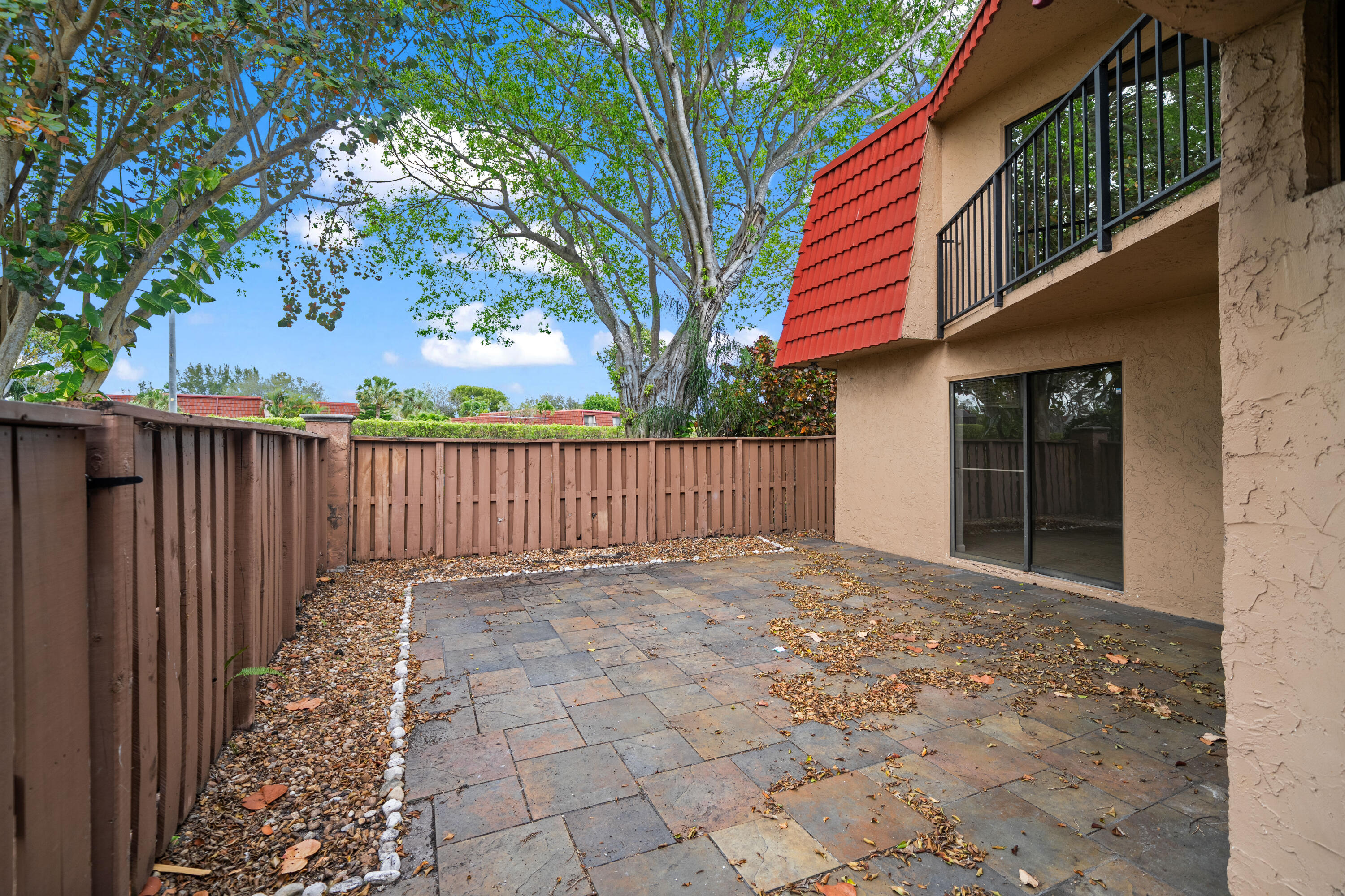 8237 Severn Drive, Unit A Boca Raton, FL 33433 - Photo 3 of 19 a view of a house with a small yard and wooden fence