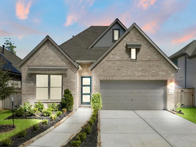 a front view of a house with a yard and potted plants