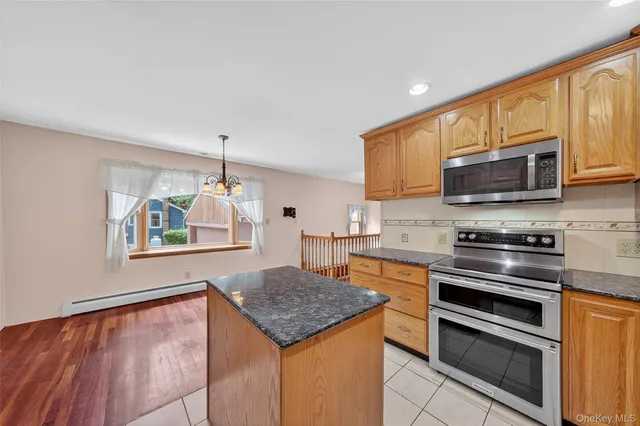 a kitchen with stainless steel appliances granite countertop a stove top oven a sink dishwasher and a microwave oven on the blue kitchen countertops