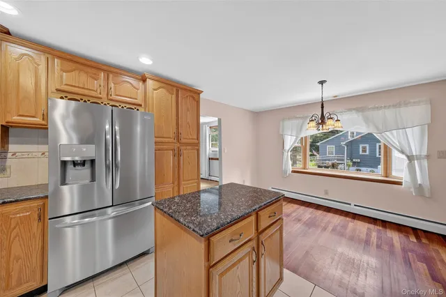 a kitchen with stainless steel appliances granite countertop a refrigerator a stove and a sink with wooden floor