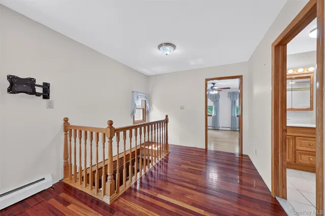 a view of hallway with wooden floor and windows