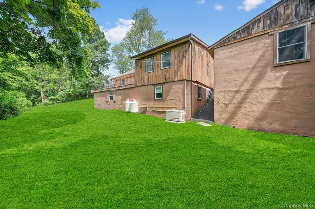 a view of a house with a big yard and large trees