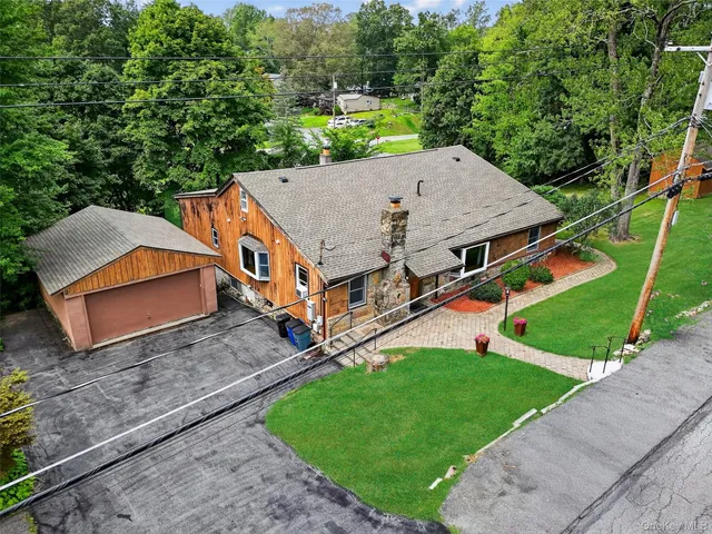 an aerial view of residential house with outdoor space and trees all around