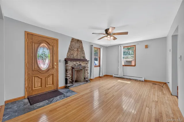 an empty room with windows and fireplace