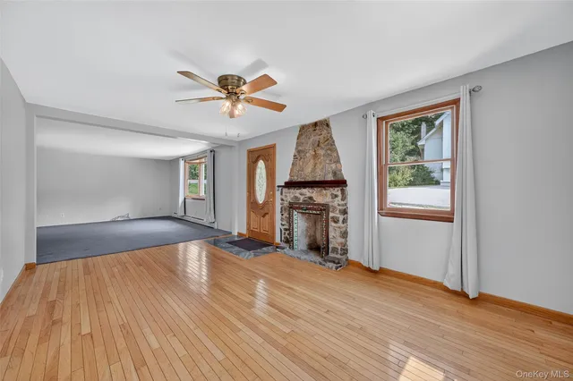 a view of a big room with wooden floor and a kitchen