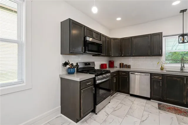 a kitchen with stainless steel appliances granite countertop a stove sink and cabinets