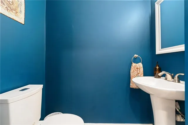 a bathroom with a sink a toilet and mirror