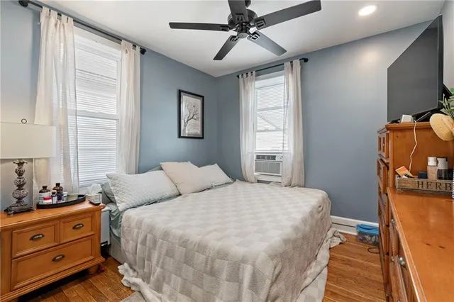 a bedroom with a bed and large windows