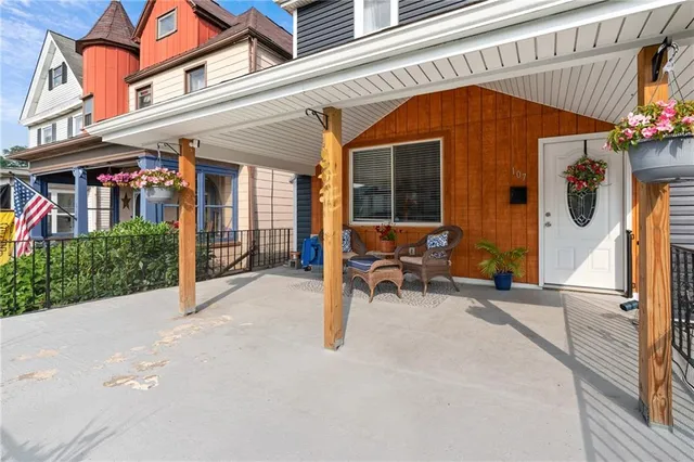 a view of a patio with table and chairs potted plants and floor to ceiling window