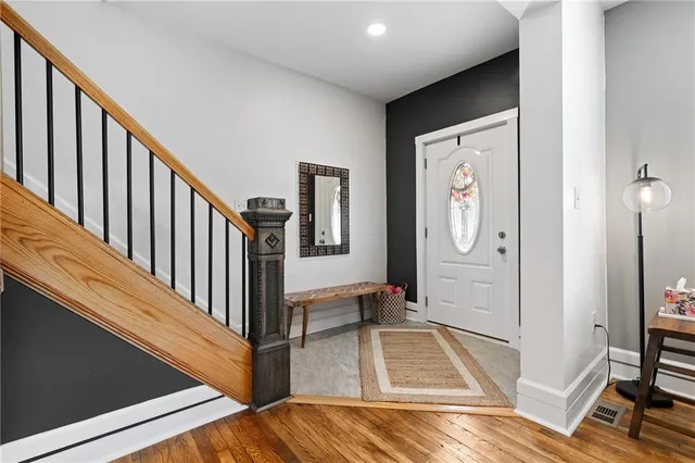 a view of a hallway with wooden floor and staircase