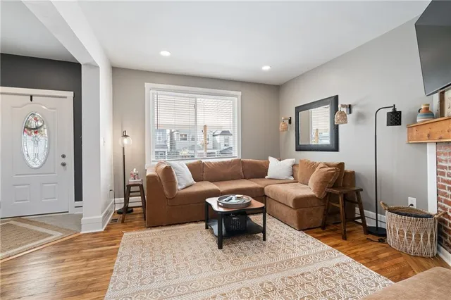 a living room with furniture wooden floor and window