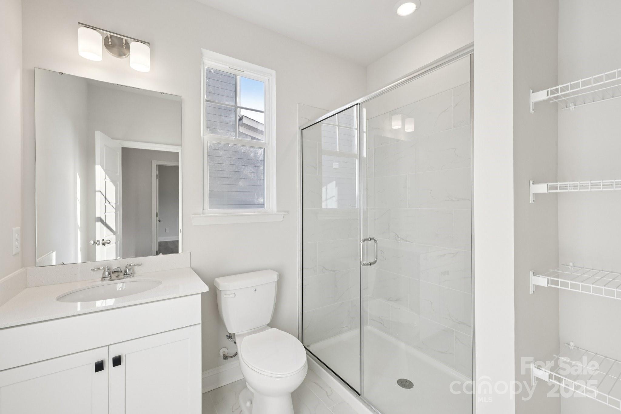 9612 Pointer Road, Unit 59 Huntersville, NC 28078 - Photo 22 of 43 a bathroom with a shower sink vanity mirror and toilet