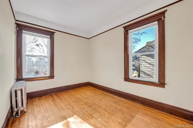 a view of an empty room with a window and a painting on the wall