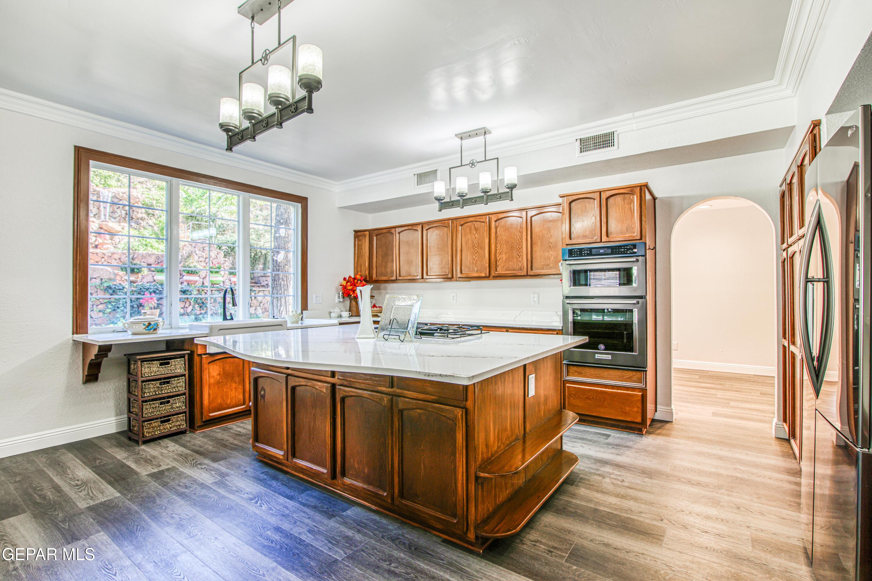 6620 Imperial Ridge Drive El Paso, TX 79912 - Photo 12 of 50 a kitchen with stainless steel appliances granite countertop wooden floors and white cabinets