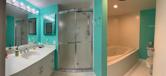 a bathroom with a tub sink and mirror