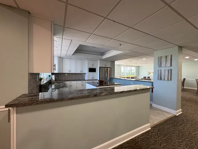 a kitchen with stainless steel appliances granite countertop a sink a stove and a refrigerator