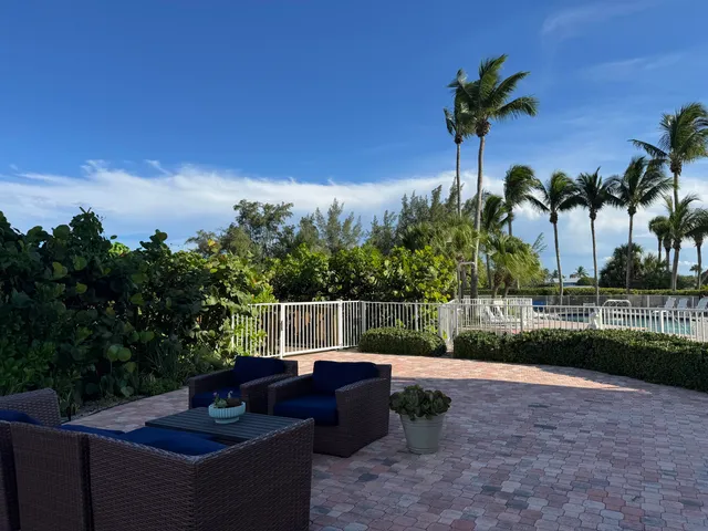 a view of a backyard with couches plants and wooden fence