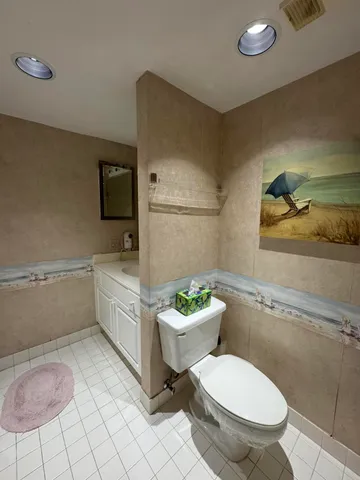 a white toilet sitting next to a bathroom sink and a shower