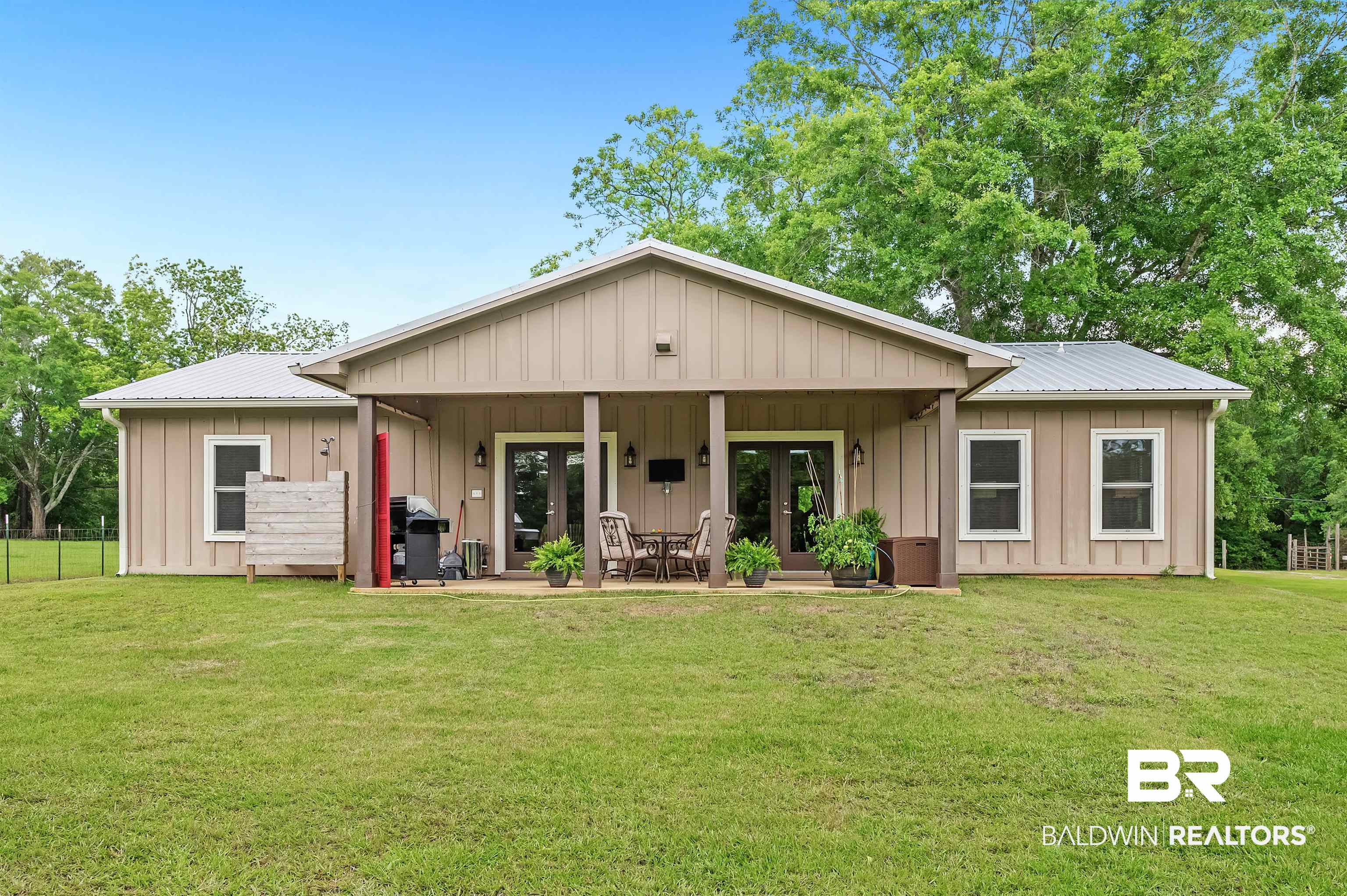 13827 County Road 83 Elberta, AL 36530 - Photo 6 of 38 View of front of property with french doors, board and batten siding, metal roof, and a patio