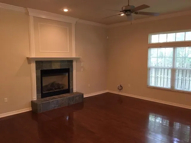 an empty room with windows and fireplace