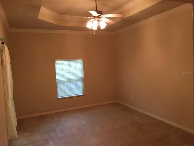an empty room with a window and a fan