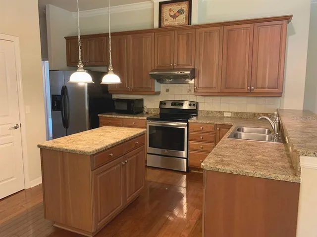 a kitchen with stainless steel appliances granite countertop wooden cabinets a stove a sink and dishwasher