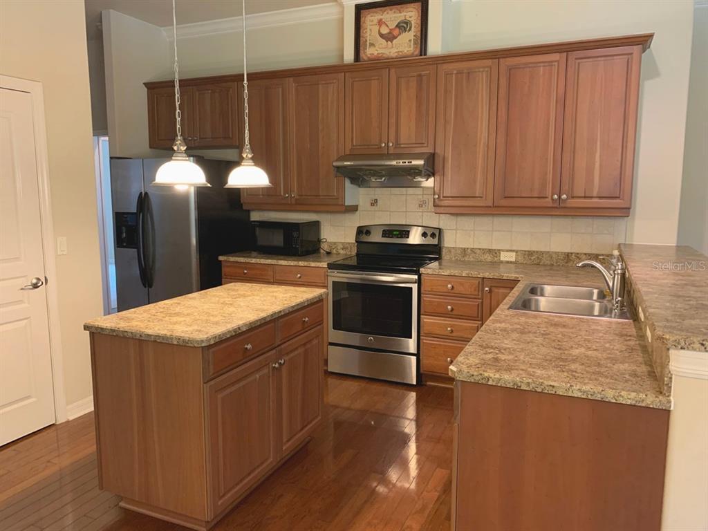 8559 Southwest 11th Road Gainesville, FL 32607 - Photo 8 of 19 a kitchen with stainless steel appliances granite countertop wooden cabinets a stove a sink and dishwasher