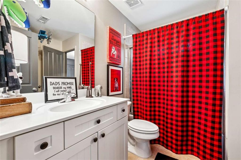 10296 Quadrant Court Alpharetta, GA 30022 - Photo 21 of 28 a bathroom with a sink toilet vanity and shower