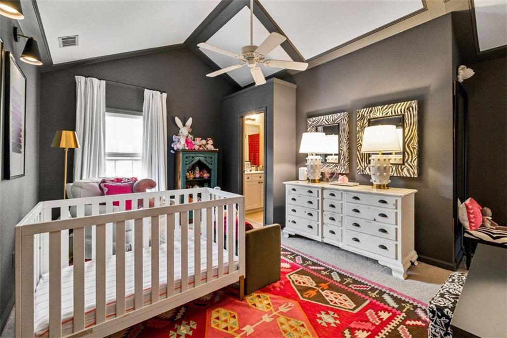 10296 Quadrant Court Alpharetta, GA 30022 - Photo 22 of 28 a bedroom with furniture a flat screen tv and a baby crib