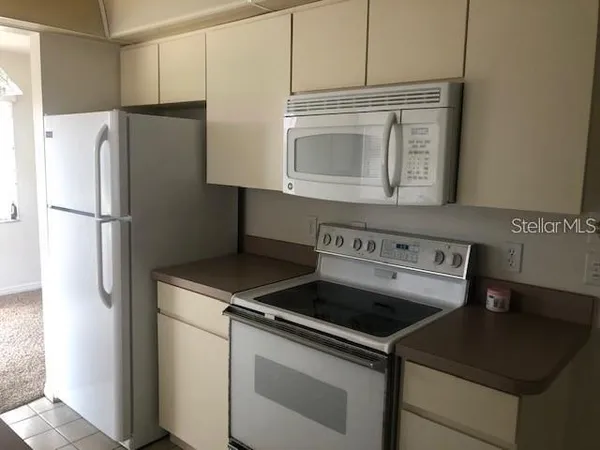 a view of a kitchen with a refrigerator sink and cabinets
