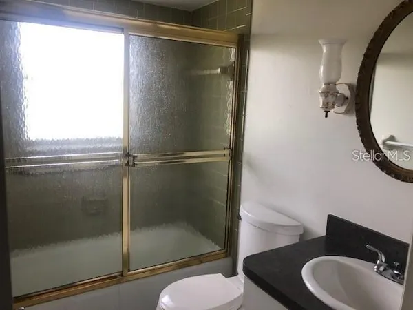 a bathroom with a shower a toilet and a sink